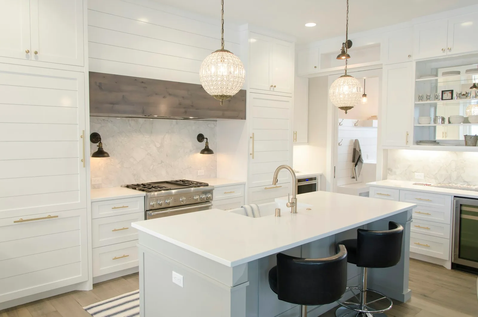 A bright white kitchen with an island and pendant lighting.